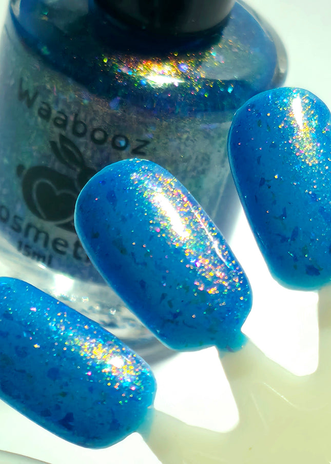 Blue glittery nail polish with a bottle labeled 'Waabooz Cosmetics' on a white background.