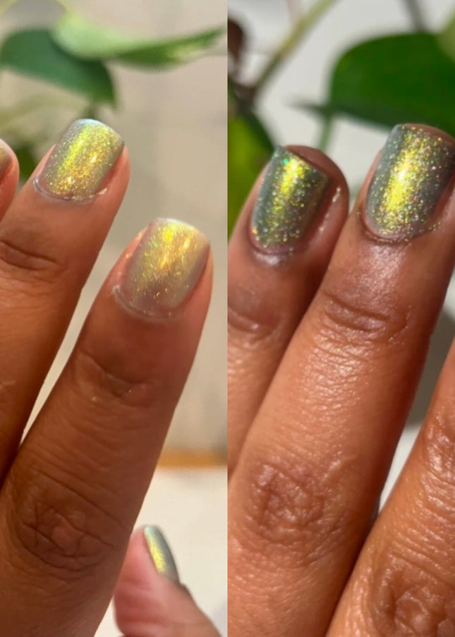 Two hands with glittery gold nail polish against a blurred green leaf background